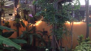 Un exuberante jardín interior con diversas plantas y una estructura de pérgola de madera.