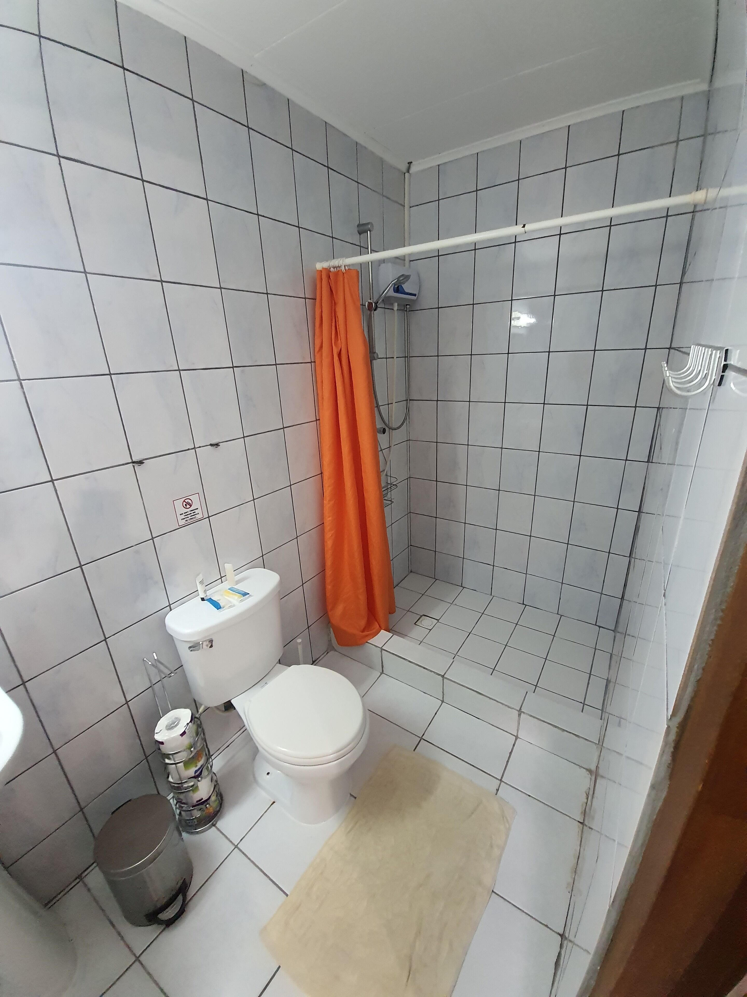 Un baño con inodoro, ducha y lavamanos.