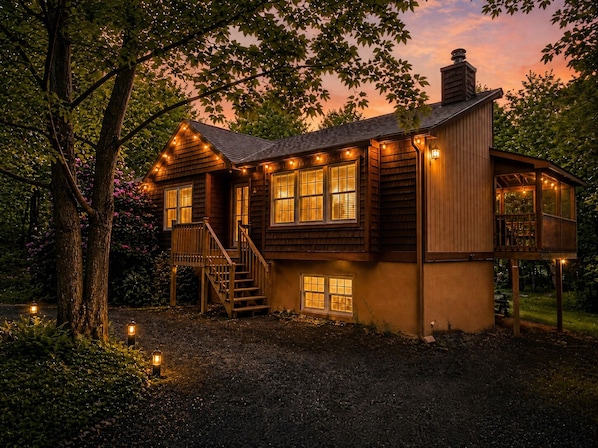 Una casa de madera con porche, varias ventanas y una escalera.