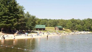 A lakeside beach with picnic areas and cabins.