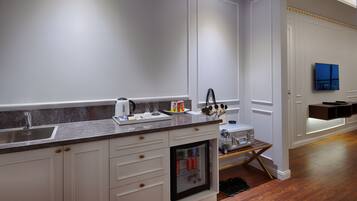 A modern kitchen with white cabinetry, a marble countertop, and a built-in refrigerator.
