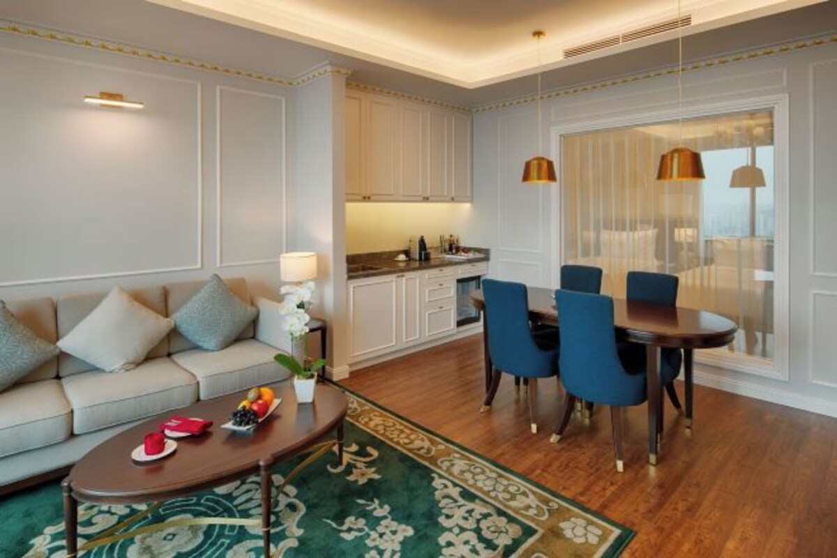A modern living room with a sofa, coffee table, and dining area with chairs.