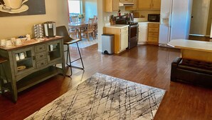 Una cocina moderna con armarios de madera, una isla central y un comedor con mesa y sillas.