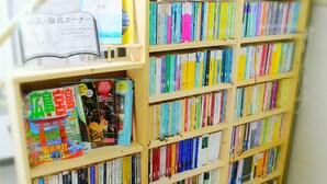 A bookshelf filled with books of various sizes and colors. - Business Ryokan Harada (Hiroshima)
