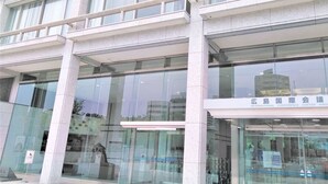 A modern building with large glass windows and a sign indicating it is the International Conference Center in Hiroshima. - Business Ryokan Harada (Hiroshima)