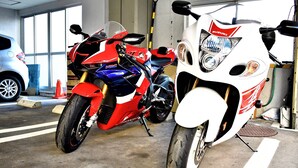 A motorcycle and a car parked inside a garage. - Business Ryokan Harada (Hiroshima)