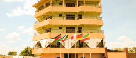 A multi-story hotel with balconies and flags.