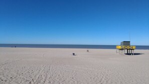 Una playa con una torre de salvavidas y un cielo despejado.