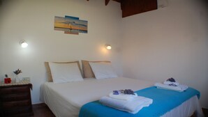 A bedroom with a bed, two bedside tables, a nightstand, a wall-mounted light, and a painting. - Near Delmar (house 3) (Mar Azul)