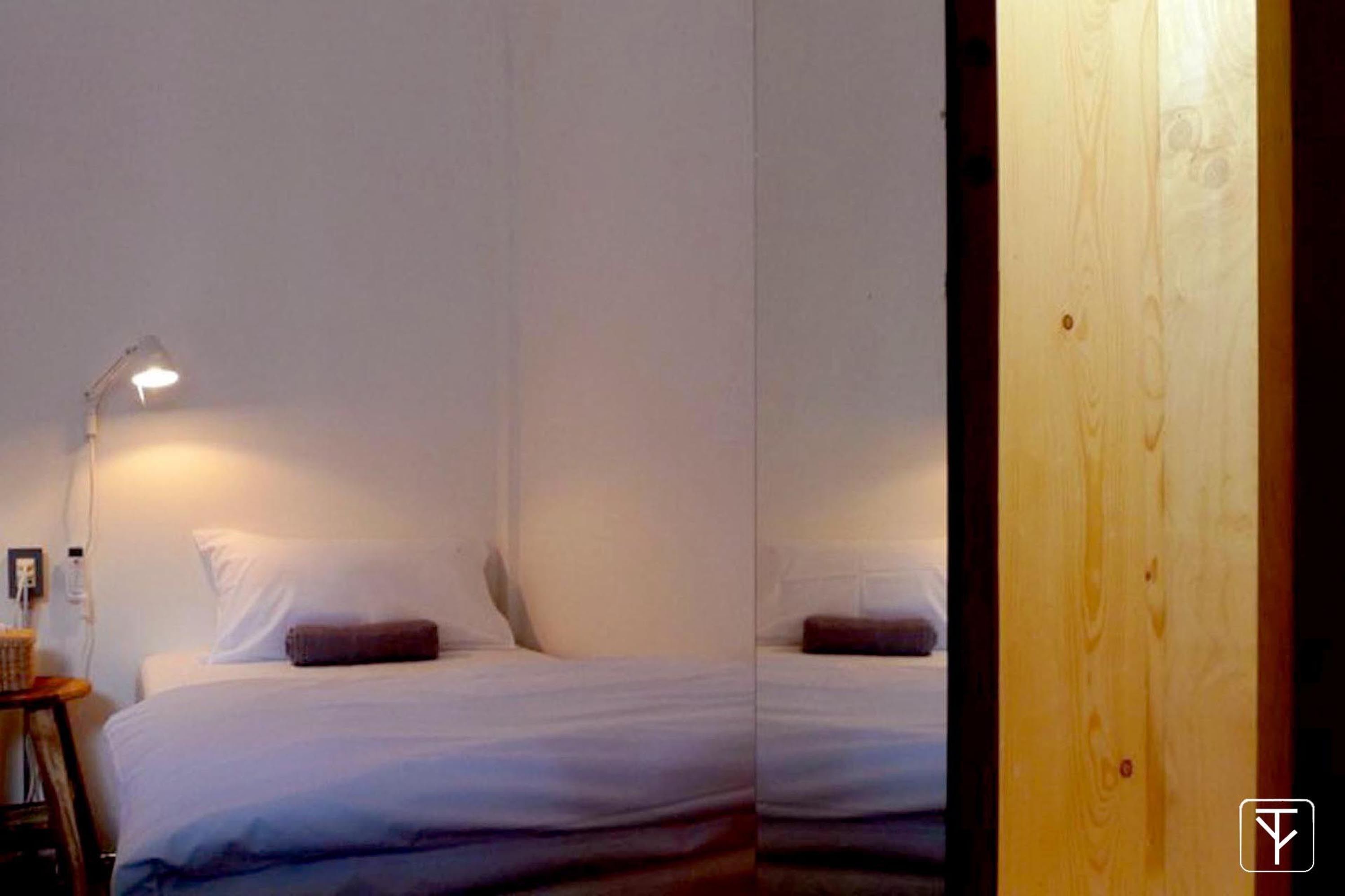 A bedroom with a bed, a nightstand, and a lamp.