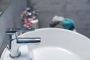 Un lavabo de salle de bain moderne avec un robinet chromé.