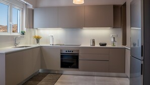 Una cocina moderna con horno empotrado, electrodomésticos de acero inoxidable y una lámpara colgante.