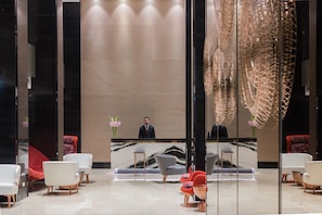 A modern lobby with a reception desk, seating area, and decorative elements.