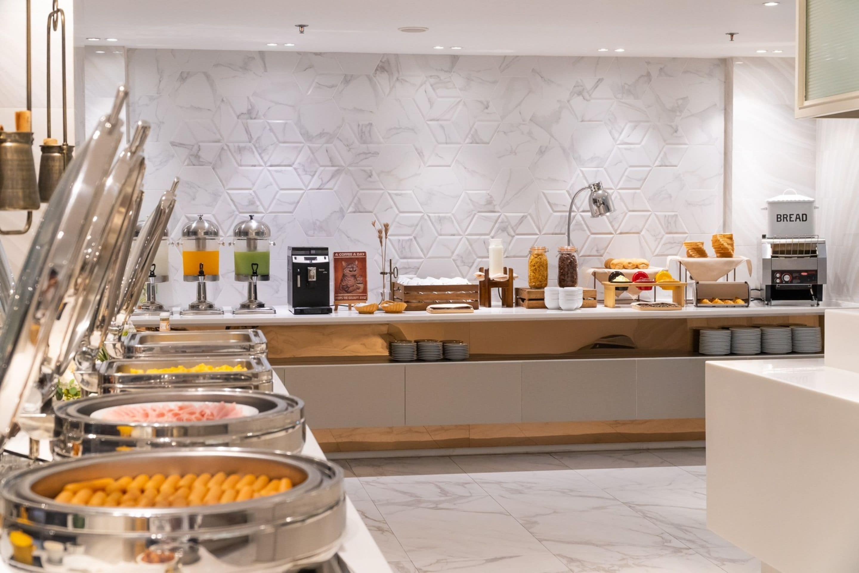 A buffet setup with various food items and a bread station.