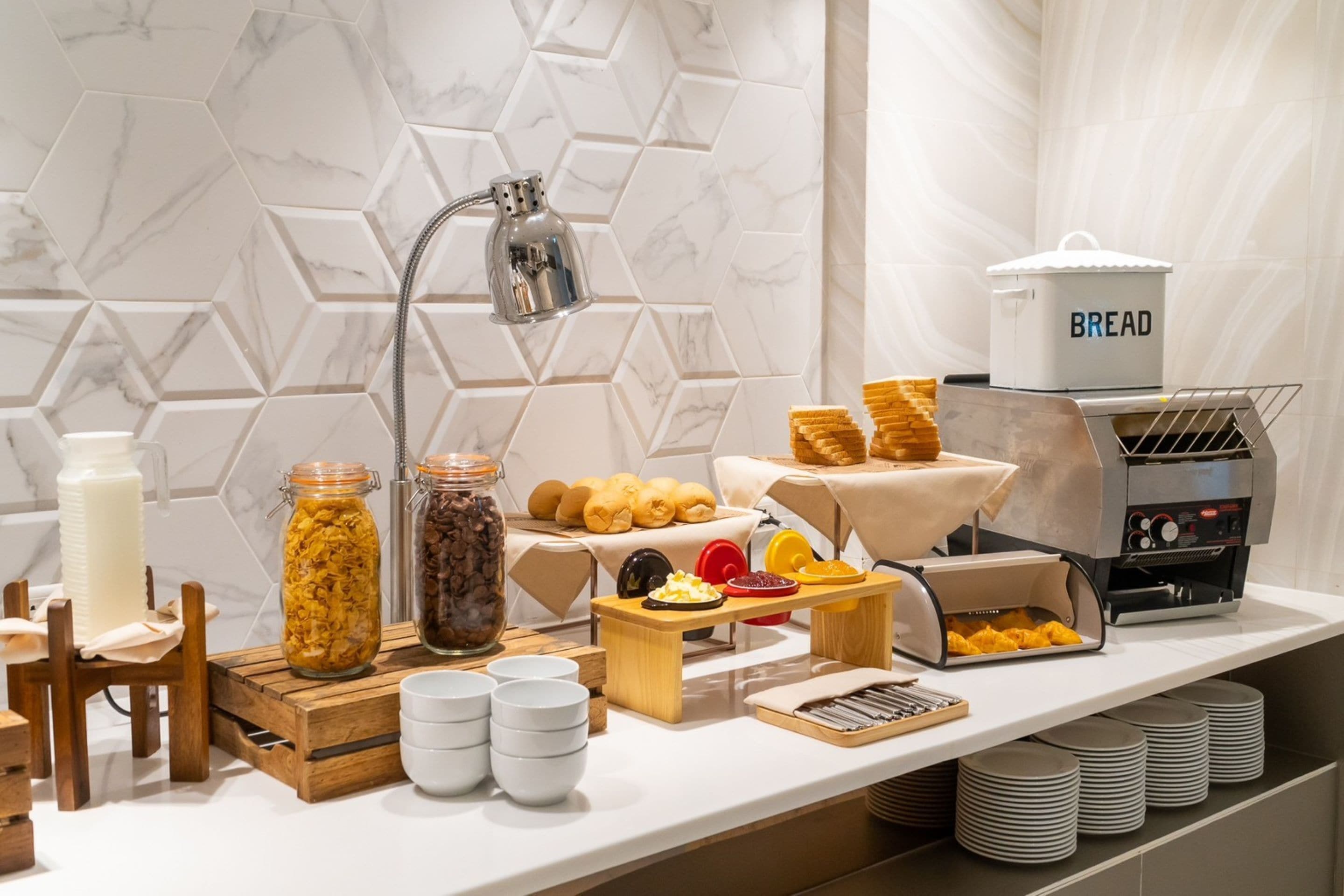 Ein reichhaltiges Frühstücksbuffet mit verschiedenen Speisen, einer Brotauswahl und einer Kaffeemaschine.
