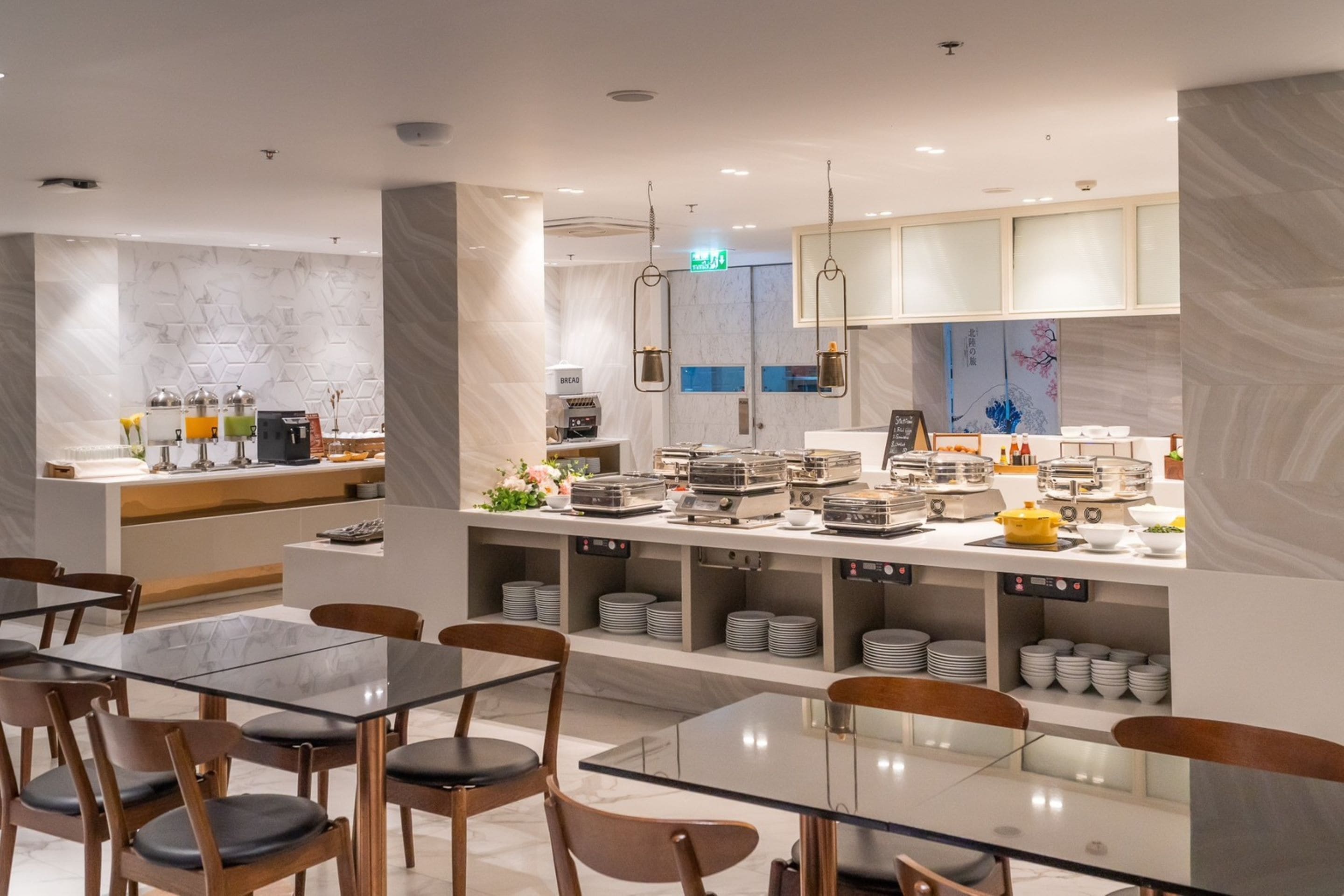 A modern restaurant with a central counter, multiple seating areas, and a variety of dining ware.