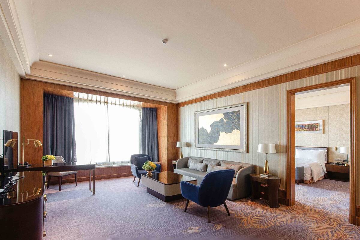 Une chambre d’hôtel avec un grand lit, un canapé, une table basse et un téléviseur.