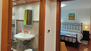 Un baño con lavamanos, espejo e inodoro.