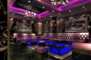 A luxurious room with a plush sofa, a chandelier, and framed artwork on the walls. - Wanhua International Hotel (Shenzhen)