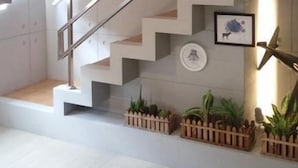 A modern staircase with a minimalist design, featuring a metal handrail and white steps. - After the Court Chiaohsi (Jiaoxi)