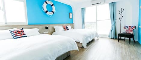 Habitación de hotel con dos camas, un flotador en la pared, perchero y una ventana con cortinas.
