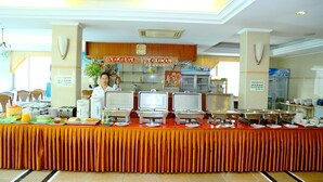 A buffet setup with multiple food stations and a clock on the wall. - Asia Palace Hotel (Phnom Penh)