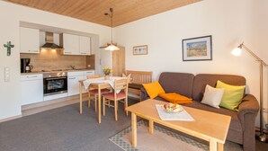 A compact living space with a kitchenette, dining area, and seating area. - Ferienwohnungen Wölfl (Bodenmais)