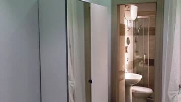 A bathroom with a toilet, sink, and shower.