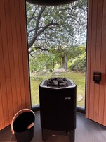 Una habitación moderna con un ventanal grande, una parrilla negra y suelo de madera.