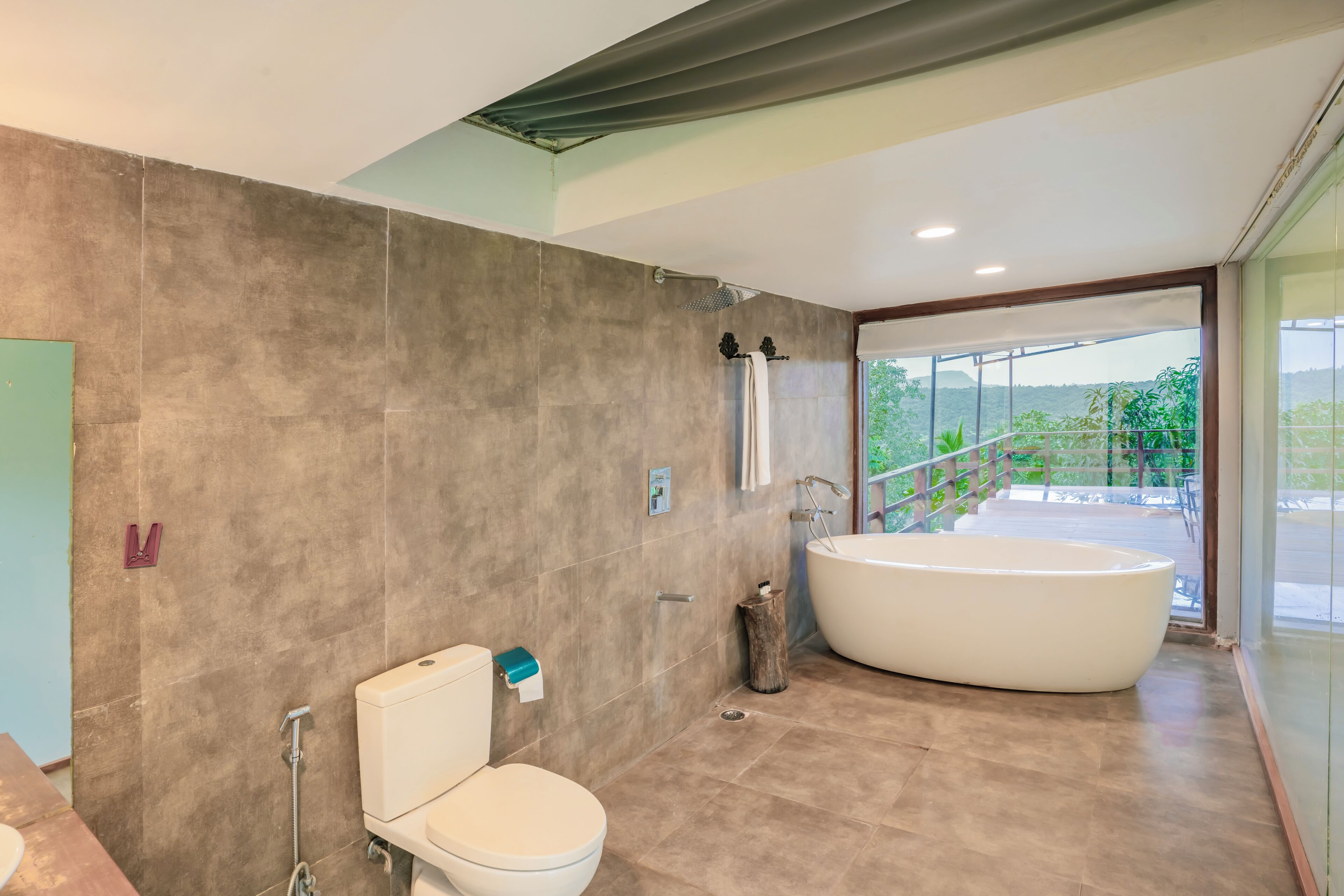 A modern bathroom with a large bathtub, a toilet, and a shower.