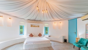 A spacious bedroom with a large bed, a curved ceiling, and multiple windows. - Forest Hills at Tala (Tala)