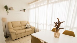 A living room with a beige sofa, a white dining table, and yellow chairs. There is a floor lamp and a plant on a shelf. - A37 APOLO 4 ESC 4 4º 16 (Calpe)