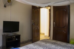 Habitación doble Deluxe | Tabla de planchar con plancha y ropa de cama