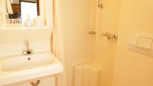 A bathroom with a sink, shower, and toilet. - Gästehaus Ethiko (Ettal)