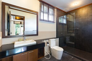 A bathroom with a black countertop sink, a white toilet, and a glass-enclosed shower. - Thai Balinese 3BR Pool Villa Alex Rawai (Rawai)