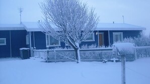 Una casa cubierta de nieve con una puerta y ventanas visibles.