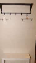 Un gabinete blanco con un estante de metal negro encima.