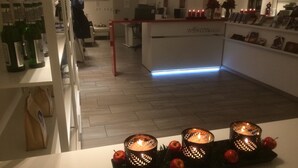 A reception area with a 'willkommen' sign, a reception desk, and a display of books and flowers. - Arnulfsplatz Aparts (Regensburg)