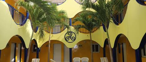 Una piscina interior con sillones de descanso y palmeras.