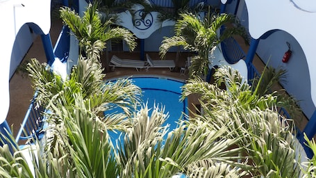 Una piscina al aire libre, sillones reclinables de piscina