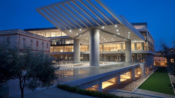 A modern building with a glass facade, large columns, and a covered walkway. - A Diamont with amazing view (Athens)