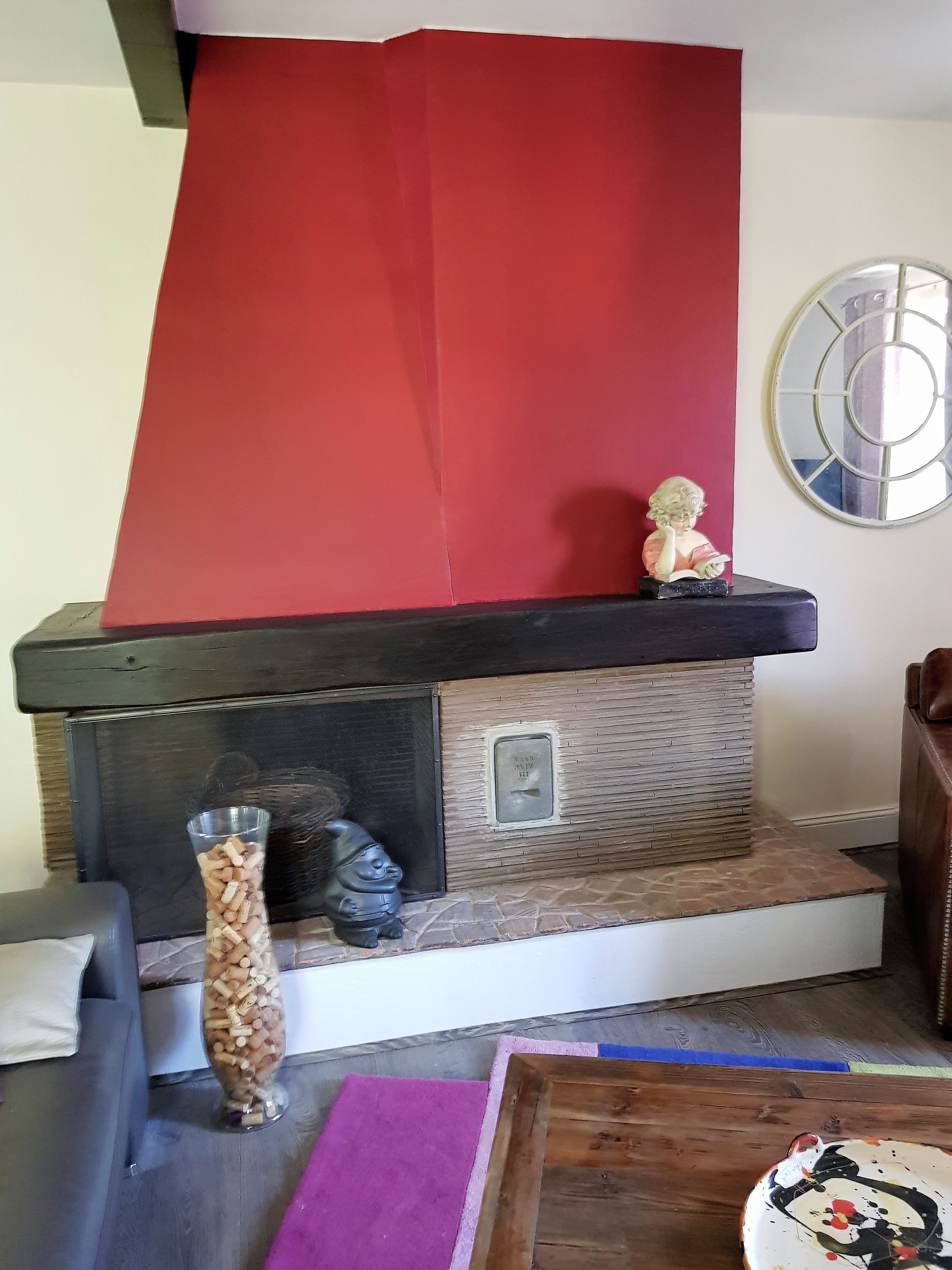 Una habitación con chimenea, una estatua y un espejo decorativo.