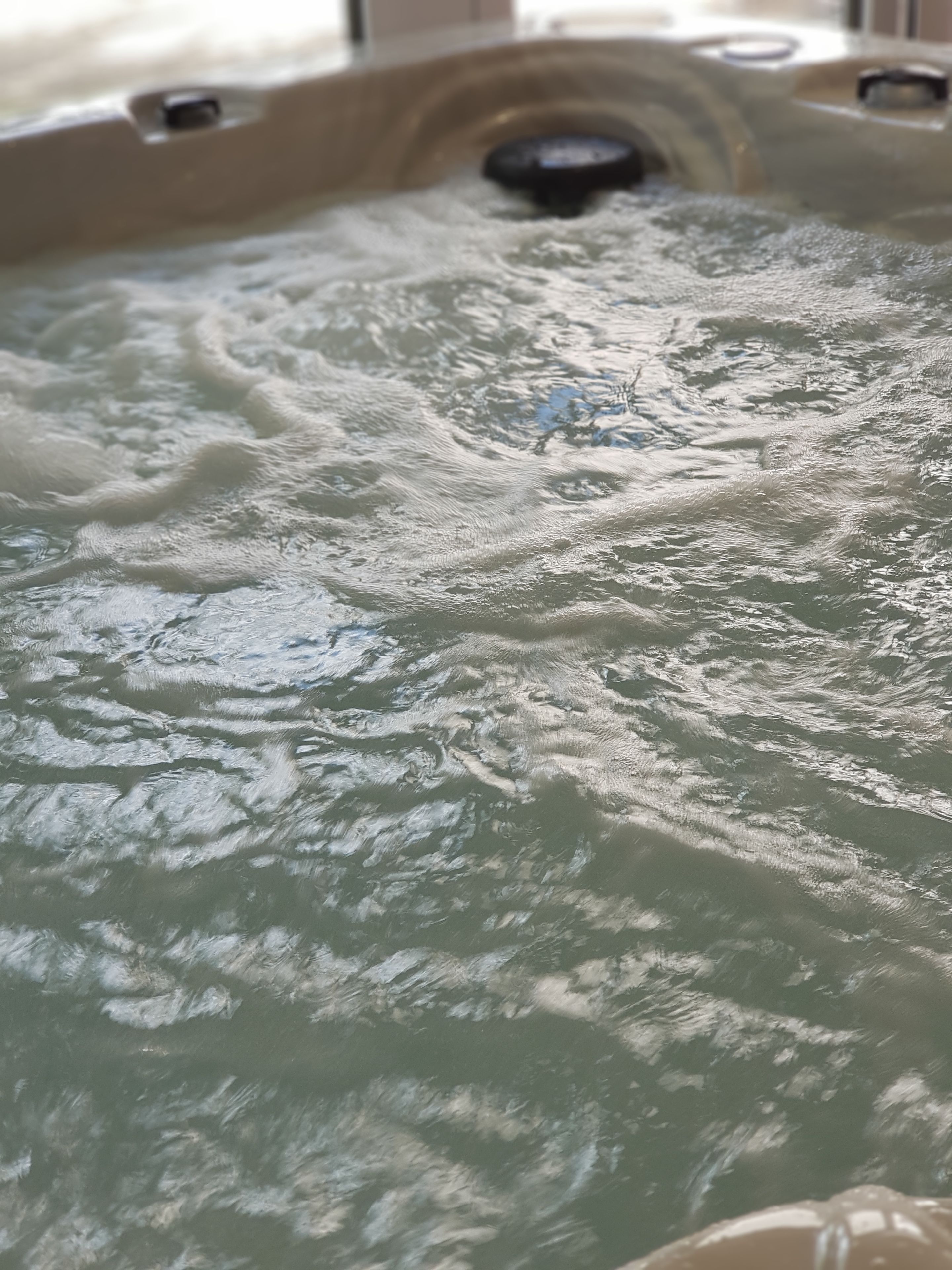Un bain à remous avec des bulles visibles et un drain au centre.