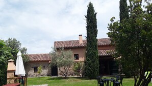 A courtyard with a stone building, a picnic table, and outdoor seating.