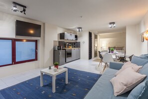 A modern apartment with a kitchen, dining area, and living room.