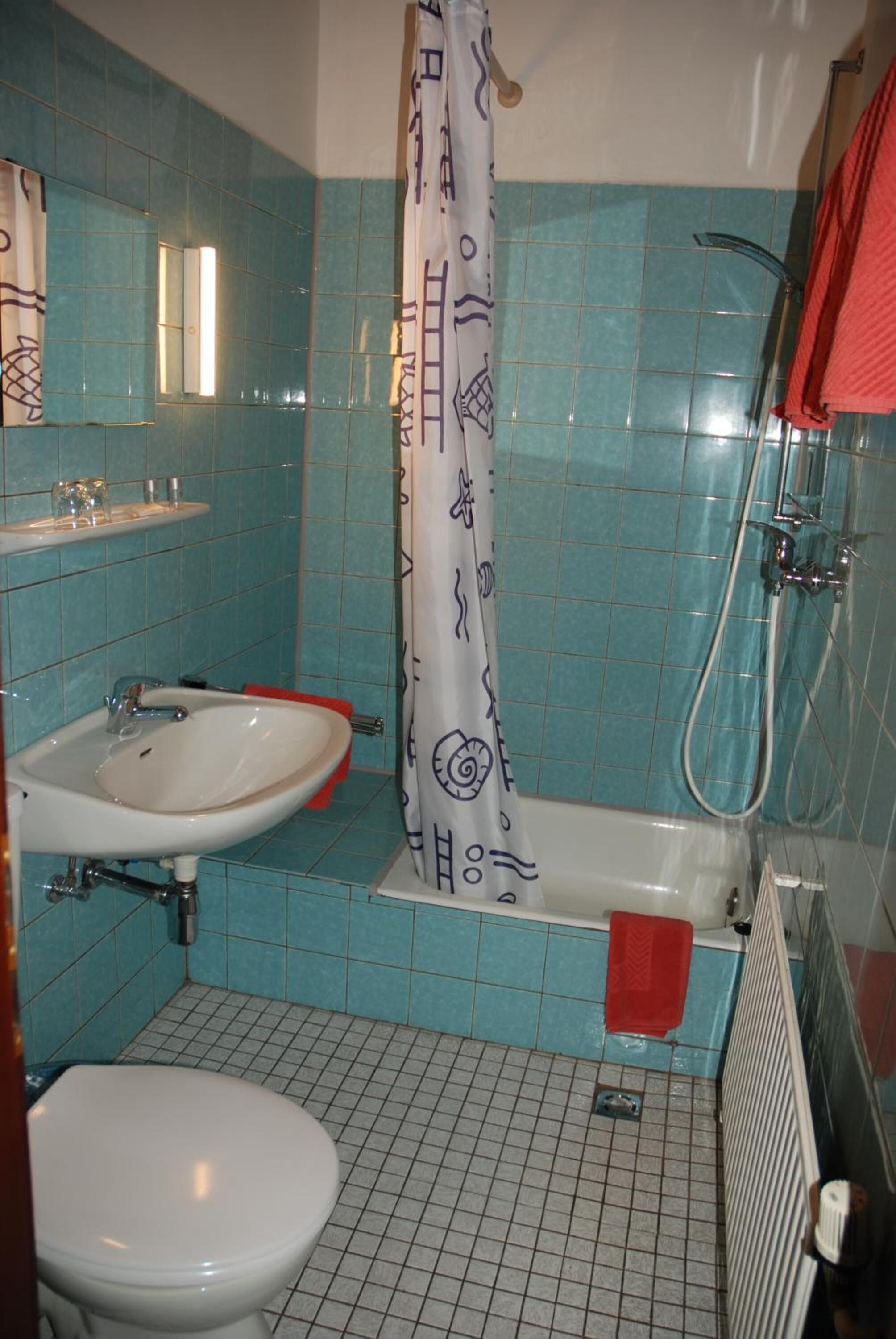 Ein Badezimmer mit Waschbecken, Toilette und Badewanne mit Duschbrause.