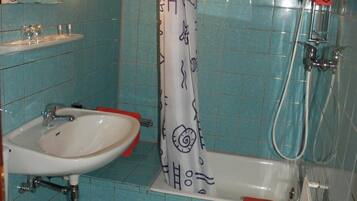 Ein Badezimmer mit Waschbecken, Toilette und Badewanne mit Duschbrause.