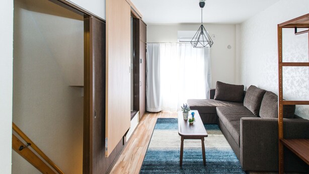 Un salon moderne avec un canapé, une table basse et un luminaire suspendu.