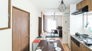 Une cuisine moderne avec des meubles en bois, une table à manger pour quatre personnes et un îlot central.