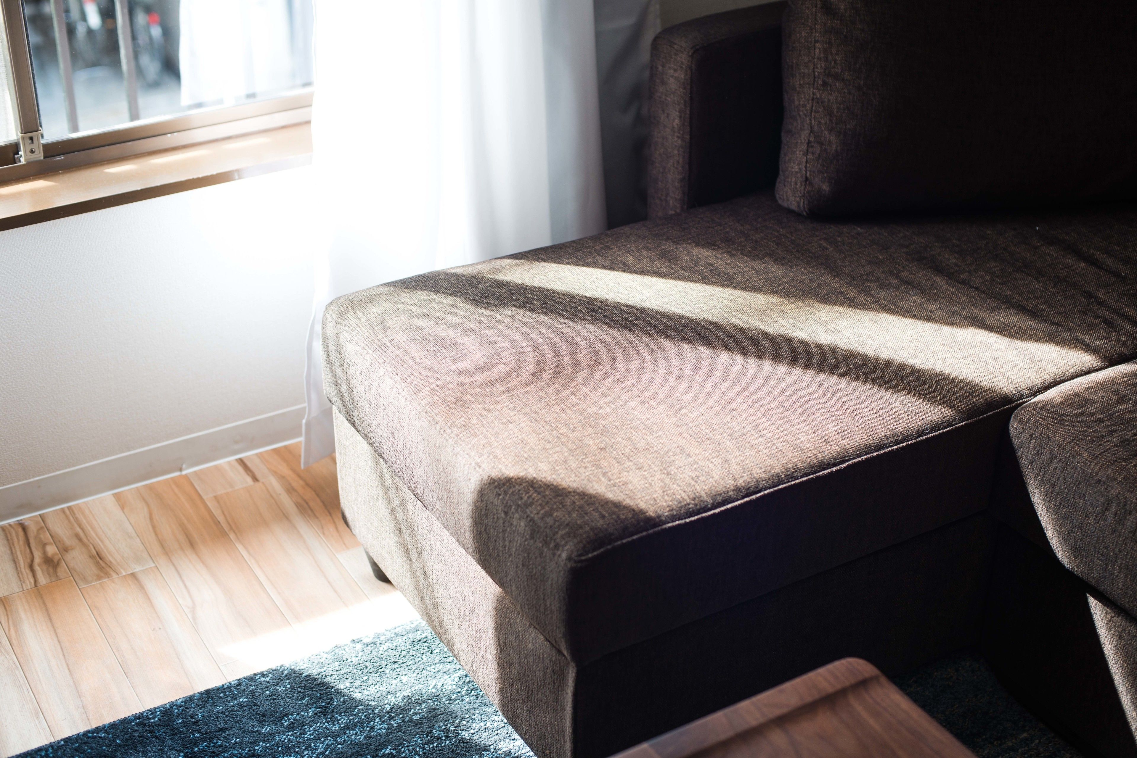 A room with a bed, a window, and a wooden floor.
